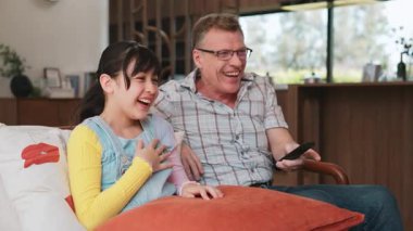 Büyükbaba ve torun birlikte TV 'de ilginç bir eğlence medyası izliyorlar. Eski üst düzey kullanım teknolojisi, genç nesil çapraz nesil ile iletişim kurarak aile bağlarını güçlendiriyor. Uyumsuzluk.