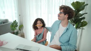 Komik beyaz bir baba ve Amerikalı bir çocuk dudak ve burun arasına kalem koyarken komik bir yüz ifadesi takınıyorlar. Birlikte mühendislik komut yazma ve masadaki dizüstü bilgisayarda yapay zeka üretme üzerine sevimli bir aile çalışması. Pedagoji.