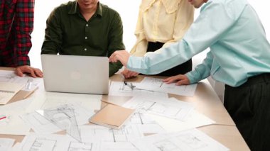 Mimarlık ve güvenlik mühendisi, modern ofiste dizüstü bilgisayarda mimari belge ve ahşap blokla sergilenen planlar hakkında tartıştı. - Yakın çekim. Tanımlama.