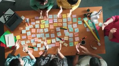 Akıllı proje yöneticisinin konuşmasının ve fikir ve alkışlamayı açıklamasının üst görüşü. İş dünyasının havadan görünüşü başarılı projeyi alkışlıyor. Toplantı odasında el çırpma takımının hava görüntüsü. Sempozyum.