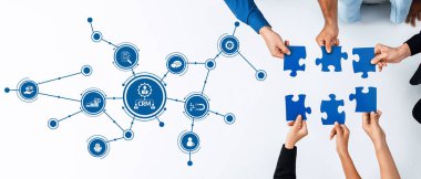 Bu resim, modern iş ortamlarında işbirliği ve bütünleşme kavramlarını gösteren bir CRM ağ grafiği ile birlikte mavi yapboz parçalarını tutan elleri tasvir ediyor. Dostluk