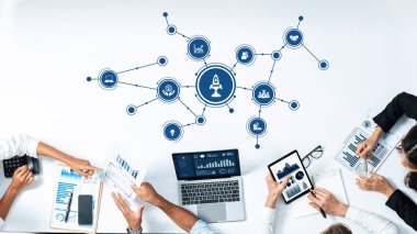 Teknoloji ve görsel verilerle çevrili bir stratejik oturuma katılan dinamik bir ekip, iş dünyasının başarısı ve büyümesi için işbirliği ve yenilikçi fikirleri vurguluyor. Dostluk