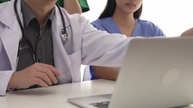 Hastane masasında birlikte çalışan ve tıbbi tedavi planlayan çeşitli profesyonel sağlık görevlileri. Takım çalışması başarılı hastalıklara ve hastalıklara yol açar. Ağır çekim. Katı.