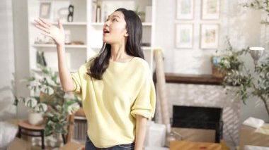 Anahtarı elinde tutan genç girişimci, merkez büroda dikilirken. Küçük işletmeleri yönetmek ya da başlamak için anahtarı taşırken kameraya özgüvenle bakan mutlu kadın satıcı. Myrmidon.