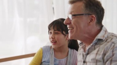 Büyükbaba ve torun birlikte TV 'de ilginç bir eğlence medyası izliyorlar. Eski üst düzey kullanım teknolojisi, genç nesil çapraz nesil ile iletişim kurarak aile bağlarını güçlendiriyor. Uyumsuzluk.