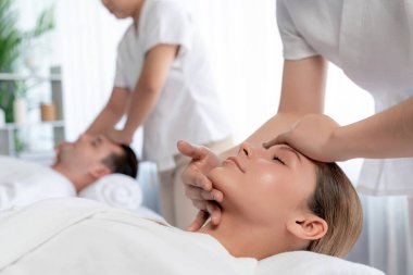 Kafkasyalı çift stres önleyici kafa masajının keyfini çıkarıyor ve lüks otellerde ya da otel spa salonlarında gündüz kaplıcalarında yüz güzelliği eğlencelerini şımartıyor. Sessiz.