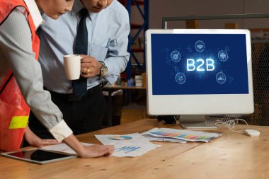 İş adamı B2B peyzajında geziniyor, iş-iş bağlantılarını geliştirmek için kullanım teknolojisi kullanıyor. B2B etkileşimini yeniden şekillendiren keşifler, iş-iş stratejilerinde yenilikleri yönlendiren araçlar. canlı