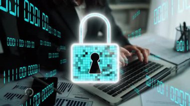 Bir iş adamı dijital güvenlik unsurlarıyla çevrili bir dizüstü bilgisayarla uğraşır, çağdaş bir çalışma alanında siber güvenlik teması ve veri görselleştirmesi sergiler. Xenic