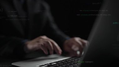 Dizüstü bilgisayarın klavyesine yazılan ellerin yakın plan görüntüsü, görüntüyü kaplayan kodların soyut bir temsili, teknoloji ve programlama temaları çağrıştırıyor. Xenic