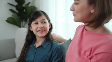 Mutlu anne oturma odasında otururken kızıyla deneyim paylaşıyor. Kafkas anne ve mutlu çocuk konuşuyorlar ve birlikte vakit geçiriyorlar. Çekici kız gülümserken ebeveyn hikayesini dinler. Pedagoji.