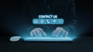 Parlak dijital temas simgeleriyle klavyeye yazı yazan ellerin yakın çekim görüntüsü. Bu görüntü, etkin iş erişimi için modern iletişim yöntemlerini temsil ediyor. Dörtgen