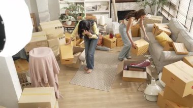 Lezbiyen aşıklar oturma odasının zeminine kutu yerleştirip dans ediyorlar. Çekici bir arkadaş birlikte çalışıyor ve karton kutuyla çevrili bir odada müzik eşliğinde yeni bir eve taşınıyor. Myrmidon.
