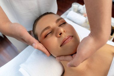 Kafkasyalı kadın stres önleyici kafa masajından ve lüks tatil beldesi ya da otel spa salonundaki modern ışık ortamında yüz güzelliği eğlencelerini şımartmaktan hoşlanıyor. Sessiz.