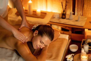 Beyaz kadın müşteri stres önleyici spa masajının keyfini çıkarıyor ve lüks otel ya da otelde sıcak mum ışığında güzellik teniyle eğleniyor. Sessiz.