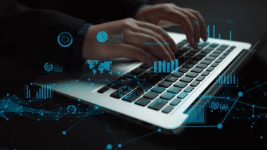 Gösterişli bir ofiste dizüstü bilgisayarla uğraşan bir profesyonel, yukarıda dijital grafikler ve grafikler olarak yazı yazan elleri gösteriyor, veri odaklı karar vermeyi simgeliyor. Xenic