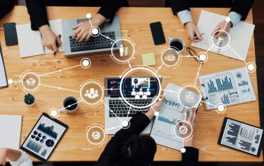 Modern ofis ortamında veri analizi, strateji geliştirme ve etkili iletişim yapan profesyonellerin yer aldığı dinamik işbirlikçi bir toplantı sahnesi. Dostluk