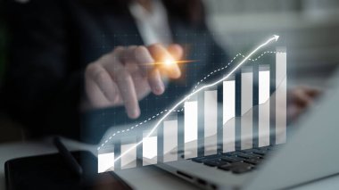 İş dünyasından profesyoneller bir dizüstü bilgisayardaki veri eğilimleriyle ilgilenerek, dijital bir grafik aracılığıyla büyümeyi ön plana çıkarıyor ve finans ve stratejik planlamada başarıyı temsil ediyor. Etki