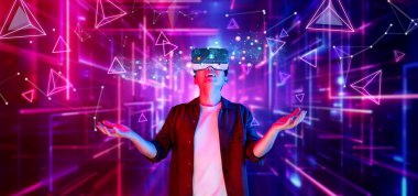 Sanal gerçeklik kulaklığı takan bir kişi, yüzen geometrik şekiller ve canlı renklerle dolu canlı bir dijital ortamda ilgi çekici bir deneyimden zevk alır. XDMCP