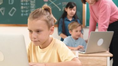 Beyaz çocuk çeşitli öğrenci kodlama mühendisliği komut ile çevrili kameraya bakarken programlama sistemine odaklanıyor. Happy öğretmen bilgisayar dersinde dizüstü bilgisayarda çalışan çocuklara destek oluyor. Pedagoji.