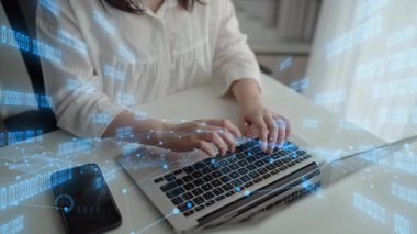 Dijital grafikler ve veri görselleştirmeleri arasında bir kişi dizüstü bilgisayara yazar. Teknoloji, iş ya da veri analizi temalarını tasvir etmek için ideal. Xenic