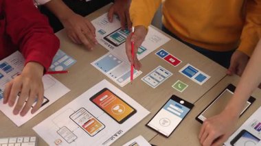 Mobil uygulama veya web sitesi için kullanıcı arayüzü prototipi planlayan akıllı bir şirket çalışanı grubu. Zekice UX UI tasarım beyin fırtınası kullanıcı dostu arayüz planı tasarlıyor. Sinerjik