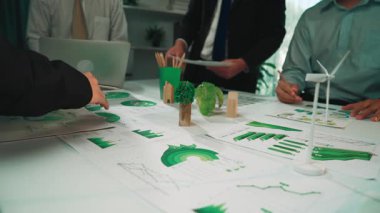 Çağdaş bir ofis ortamında çeşitli sürdürülebilirlik çizelgeleri ve diyagramlarını analiz ederek strateji ve büyümeyi vurgulayan çeşitli bir iş ekibi ayrıntılı bir tartışmaya girişir. SACTR