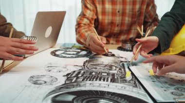 Çeşitli profesyonellerden oluşan bir grup, modern bir çalışma alanı ortamında teknik çizimler, dizüstü bilgisayarlar ve araçlardan yararlanan bir mühendislik projesinde işbirliği yapmaktadır. SACTR