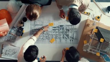 Becerikli mühendis ekibinin ev inşaatından bahsedişinin en alt görüntüsü. Mimar ya da tasarımcı grubunun planlar hakkında beyin fırtınası yapmak için tartışan ve yazan hava görüşü. Hizalama.