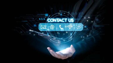 Bir kişi yüzen bir arayüze doğru elini uzatarak çeşitli temas seçenekleri sunuyor, günümüz teknolojisiyle modern iletişimi ve dijital bağlantıyı sembolize ediyor. Dörtgen