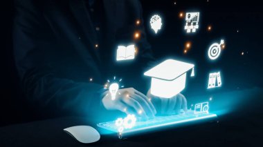 Bilgisayar klavyesinden ortaya çıkan holografik simgelerle öğrenmenin ve yeniliğin görsel temsili, karanlık bir ortamda modern eğitimi ve dijital dönüşümü sembolize ediyor. Dörtgen