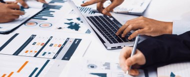 Çeşitli bir iş ekibi dijital pazarlama stratejisi üzerinde işbirliği yapıyor. Modern ofis alanını veri, grafik ve grafiklerle dolu dizüstü bilgisayarlar ve belgeler dolduruyor. SACTR