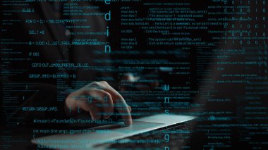 Kendini işine adamış bir programcı dizüstü bilgisayarına odaklanır ve kod satırları karanlık çalışma alanını aydınlatır, yazılım geliştirme ve teknolojik yenilikler sergiler. Xenic