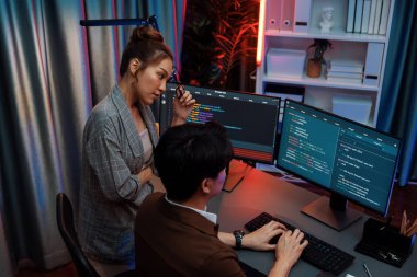 Bilgi teknolojisi modern ofisteki neon ışık odasında iki ekranın bilgisayarında veri çalıştıran akıllı web sitesi geliştirme kodlayıcı sistemi ile tartışan bilişim geliştiricileri. İnfobahn.