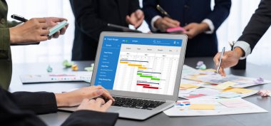 Analizci ekibi yaratıcı ve analitik beyin fırtınası fikri için bilgisayar ekranında BI veri paneli olan yapışkan bir not kullanıyor. Pazarlama stratejisi için finansal veri görselleştirme teknolojisini analiz et. Dahi.