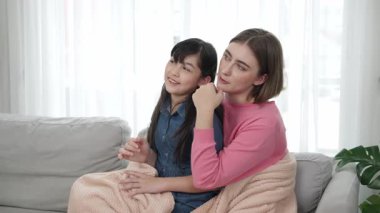 Annesi peri masalı anlatırken, mutlu kız beyaz annelerin kucağında oturuyor. Anne, kızı eve bakıp gülümserken ona sıcak bir şekilde sarılıyor. Aile birlikte vakit geçirir. Pedagoji.