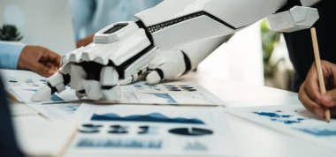 Gösterişli bir robot el, bir toplantı sırasında iş haritaları ve grafikler üzerinde profesyonellerle işbirliği yaparak, iş yerindeki teknolojinin entegrasyonunu vurguluyor. Noogenesis