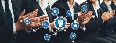 Bir grup iş adamı, bir şirket ortamında yapay zekayı, teknolojiyi ve yeniliği temsil eden dijital simgelerle çevriliyken alkışlıyorlar. Dostluk