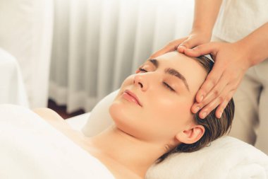 Kafkasyalı kadın stres önleyici kafa masajından ve lüks tatil beldesi ya da otel spa salonundaki modern ışık ortamında yüz güzelliği eğlencelerini şımartmaktan hoşlanıyor. Sessiz.