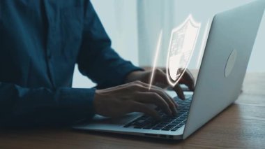 Bilgisayarda dijital güvenlik simgeleriyle çevrimiçi koruma ve siber güvenlik teknolojisini modern bir çalışma ortamında temsil eden bilgisayarlar var. Dörtgen.