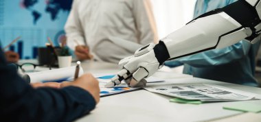 Bir robot el, çağdaş bir ofis ortamında veri analizi ve strateji geliştirmeye odaklanan bir iş toplantısında insan profesyonellere yardım eder. Noogenesis