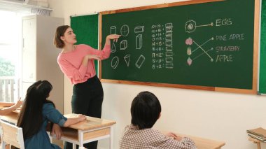 Zeki öğretmen sınıfta fikri açıklarken sevimli öğrenci ödevlerini kontrol ediyor. Not defterine bakıp matematik teorisinden çocuğa bahsederken sınıfta dolaşan çekici bir eğitmen. Pedagoji.