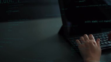 Modern bir çalışma ortamında programlama ve dijital yaratıcılığın özünü vurgulayan, bir dizüstü bilgisayarın üzerinde yazan bir elin odaklanmış görüntüsü. Xenic