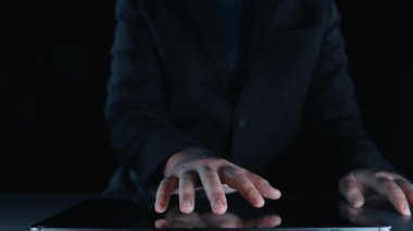 Bir kişi, parıldayan dijital bir küresel ağ ve modern teknoloji ve sanal iletişimi gösteren bir dizüstü bilgisayarın üzerindeki simgelerle etkileşimde ellerini kullanır. Dörtgen