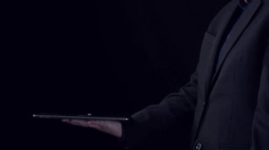 Bir işadamı güvenli bir şekilde elinde parlayan dijital bir kilidi gösteren bir tablet tutarak, ağ teknolojisi zemininde siber güvenlik ve veri korumasını temsil ediyor. Dörtgen