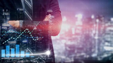 Bir işadamı, kentsel gece manzarası ortasında, üst üste binmiş mali grafiklerle, büyümeyi, başarıyı ve iş dünyasındaki karar vermeyi sembolize eden bir takım elbiseyle güvenle ayakta duruyor. Copula