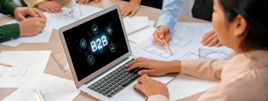 İş adamı B2B peyzajında geziniyor, iş-iş bağlantılarını geliştirmek için kullanım teknolojisi kullanıyor. B2B etkileşimini yeniden şekillendiren keşifler, iş-iş stratejilerinde yenilikleri yönlendiren araçlar. canlı