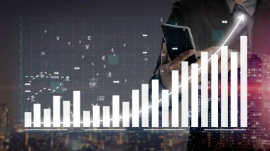 Bir işadamı gece bir şehir ortamında duruyor, bar grafikleri ve grafikleriyle sergilenen finansal veri görselleştirmelerini analiz etmek için akıllı telefon kullanıyor, büyüme eğilimlerini gösteriyor. Copula