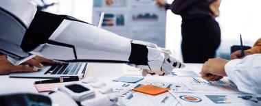 Robot Kol modern ofis ortamında insan takımını destekler, işbirliği ve yenilikçi teknoloji yoluyla veri analizi ve stratejik planlamayı kolaylaştırır. Noogenesis