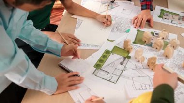 Mimari belge, ölçüm aracı ve ahşap blokların modern ofiste etrafa saçıldığı bir masa üzerinde yapı inşaatı ile ilgili mimar ve güvenlik mühendisi tartışması. Tanımlama.