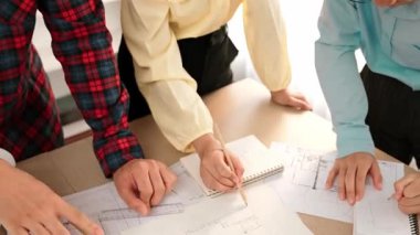 Mimarlık ve güvenlik mühendisi, modern ofiste doğruluk için mimari belge ve ölçüm aracı kullanılarak dizüstü bilgisayarın üzerinde sergilenen planlar hakkında tartıştı. - Yakın çekim. Tanımlama.